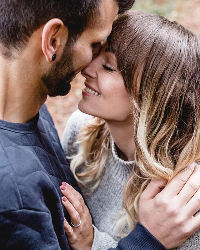 A loving couple embraces outdoors, sharing a tender moment in a natural setting. Close-up shot.