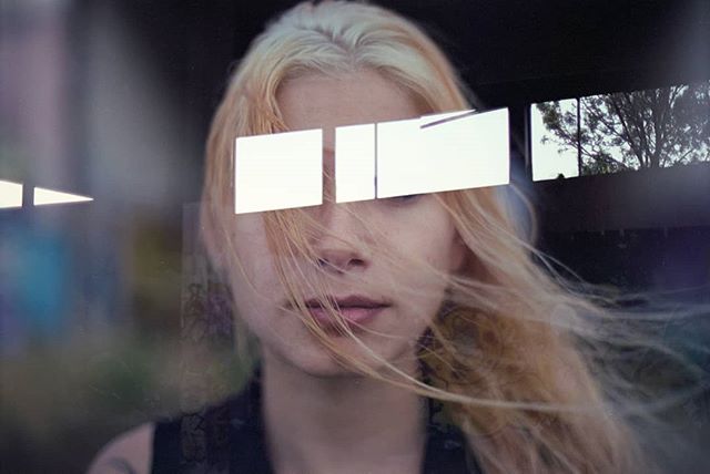 A blonde woman with geometric shapes over her eyes creates a modern, mysterious feel.