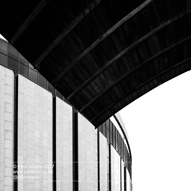 A striking architectural shot of a modern building with clean lines, captured in a high-contrast black and white.