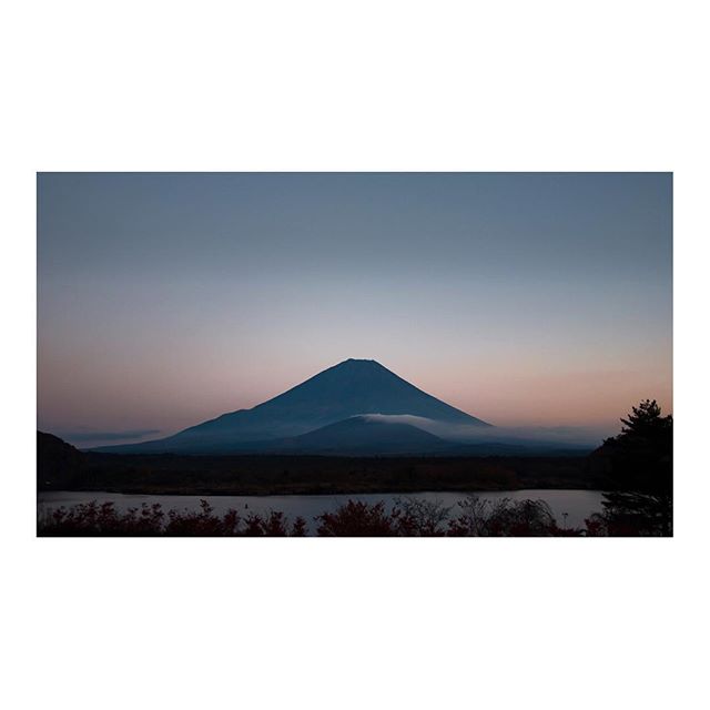 A scenic view of a mountain range reflected in calm water, under a tranquil sky. Ideal for travel and nature themes.