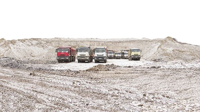 A group of heavy-duty dump trucks at a construction site, ready for material transportation and infrastructure development.