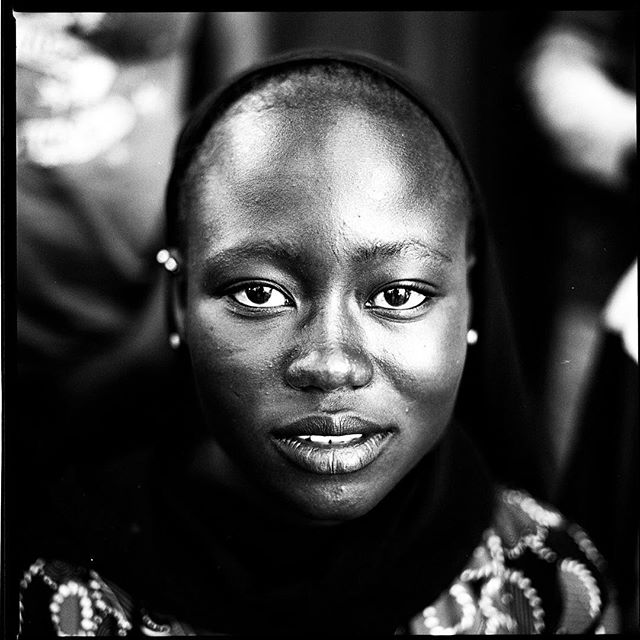 A close-up black and white portrait of a woman with a thoughtful expression.