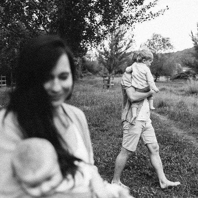 A family enjoys a tender moment outdoors in a black and white scene.