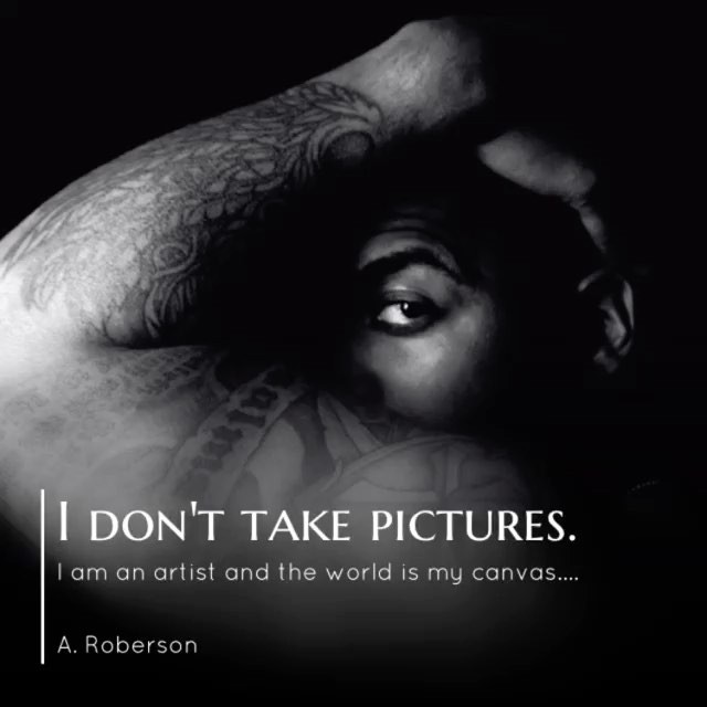 Monochrome artistic portrait of a man with tattoos, his eye intensely gazing in a close-up shot.