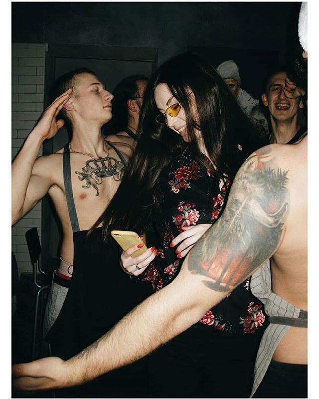 A group of people enjoying a lively party in a nightclub, captured in a candid, vintage style.