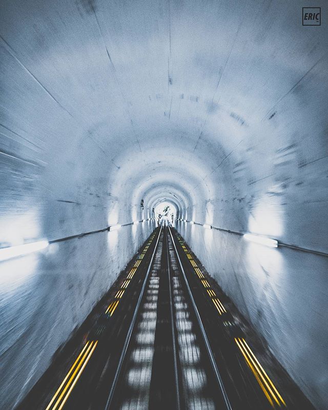 A low-angle shot captures motion blur in a tunnel with illuminated tracks, creating a mysterious and intense atmosphere.