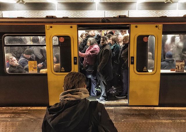 A crowded subway train with commuters during rush hour.