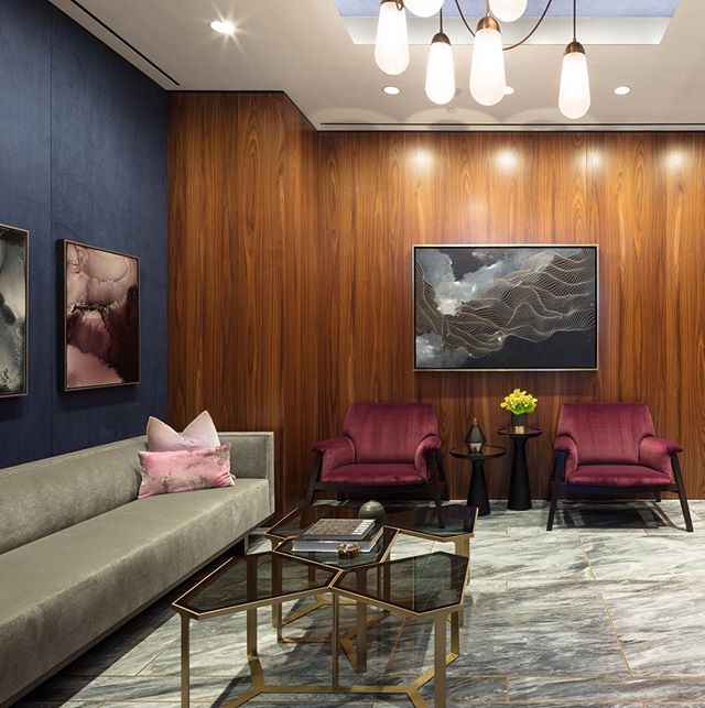 An elegant waiting area features modern furniture, artwork, and soft lighting, creating a calm and inviting atmosphere.