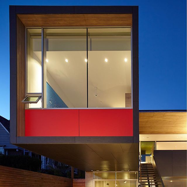 Modern architectural home featuring clean lines, a red accent wall, and strategic lighting for a luxurious living space.