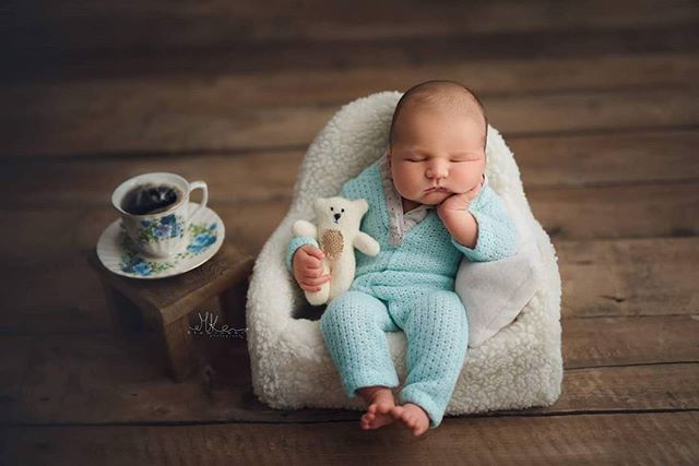A newborn baby sleeps peacefully with a teddy bear and teacup. Perfect for baby-related content and products.