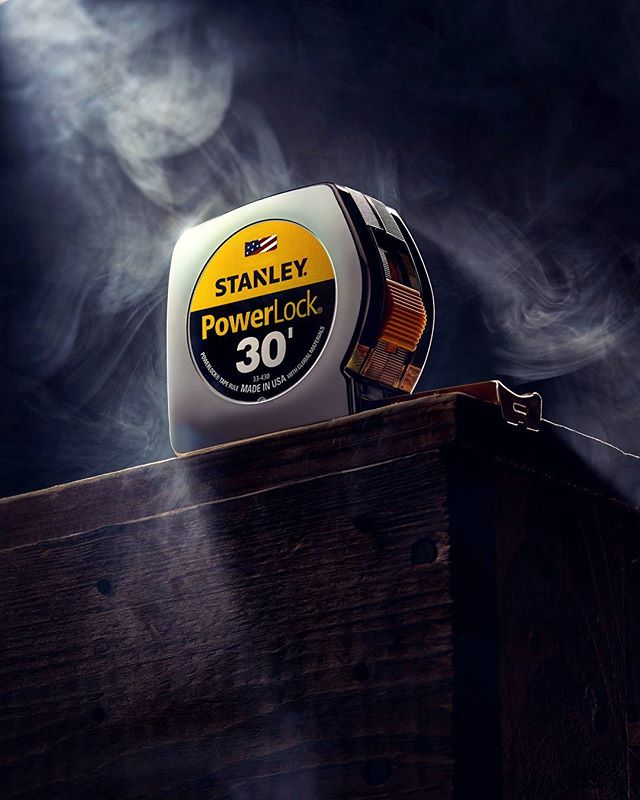 A Stanley Powerlock 30' tape measure sits on a wooden surface, highlighting the tool's precision and durability.