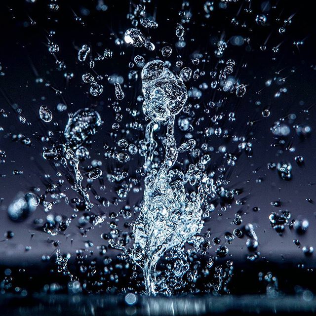 A close-up shot captures a dynamic water splash against a dark backdrop, creating a sense of refreshing tranquility.