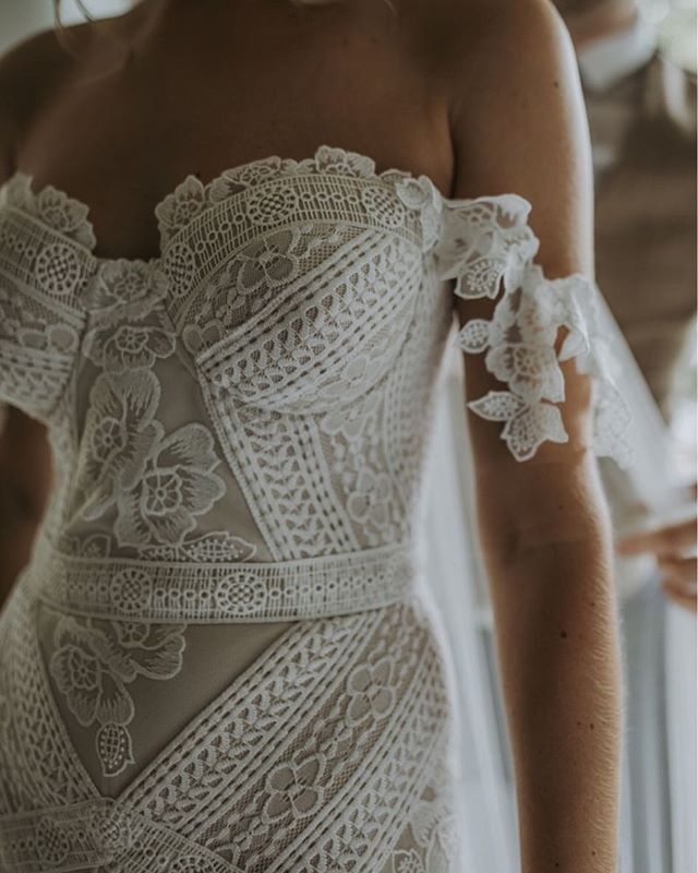 Close-up of a woman in a lace wedding dress showcasing the delicate details.  