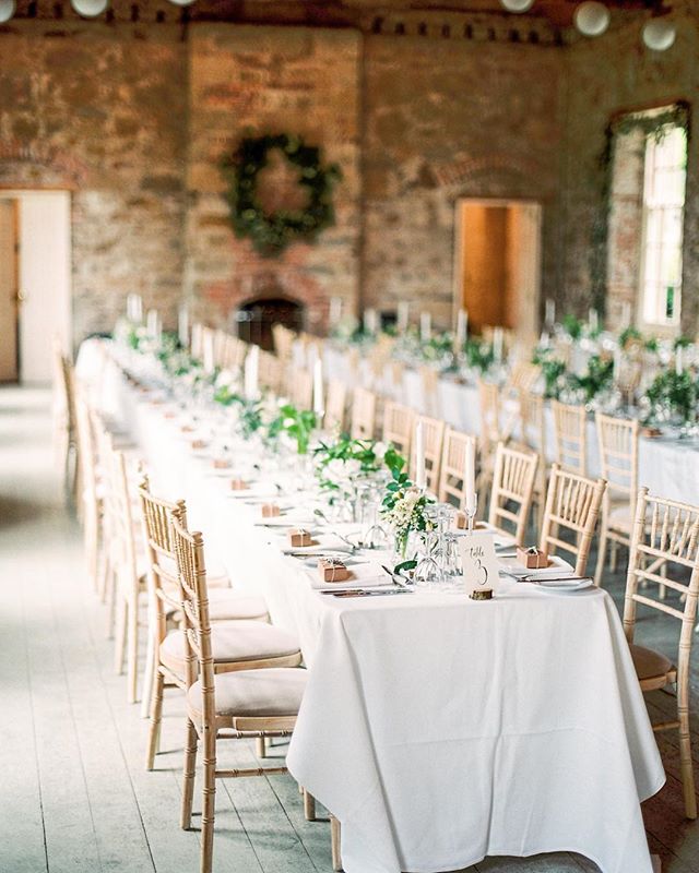Elegant wedding reception with a long table setting and classic decorations in a banquet hall.