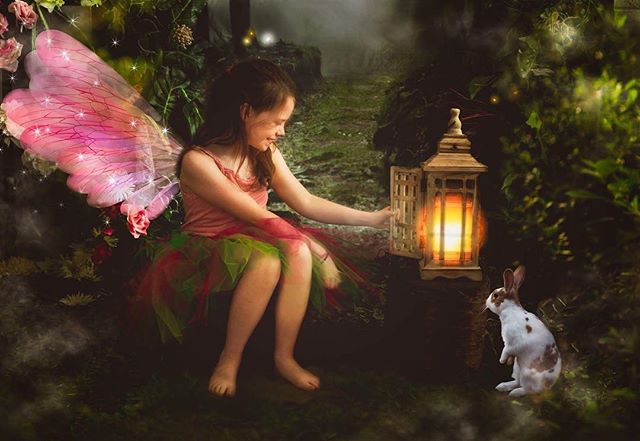 A fairy girl with a lantern meets a rabbit in an enchanted forest.