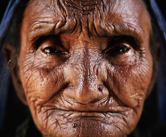 A close-up portrait of an elderly woman with wrinkled skin.