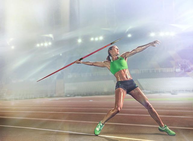 A female javelin thrower in action at a stadium, showcasing strength and determination.
