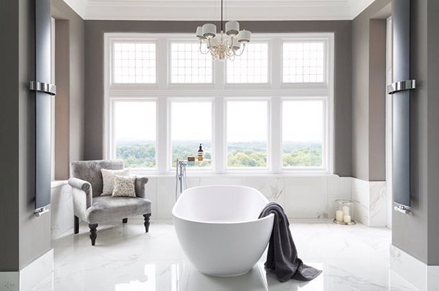 A modern, elegant bathroom featuring a freestanding tub, soft natural light, and serene atmosphere.