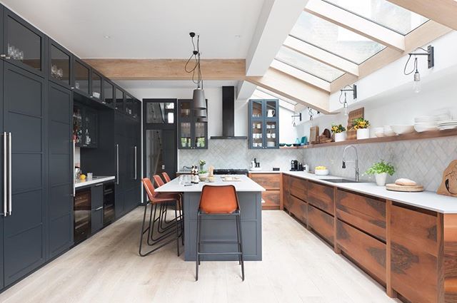 A modern kitchen with a large island, wooden cabinets, and a bright skylight for a cozy and stylish home.