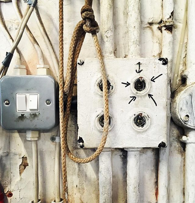 A vintage electrical panel featuring old toggle switches and wiring, showcasing industrial design.
