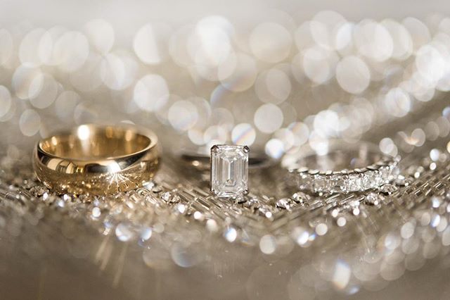 Close up of gold and diamond wedding rings on a sparkling surface, radiating love and commitment.