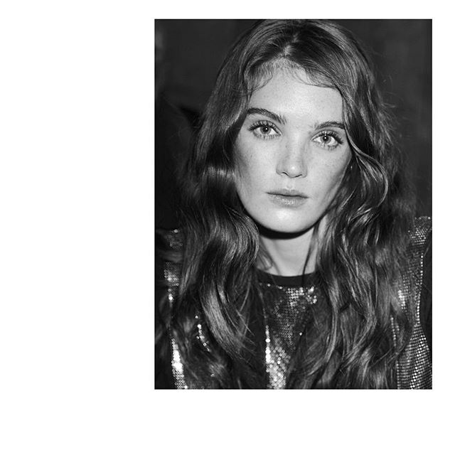 Striking monochrome portrait of a woman with long wavy hair wearing a shimmering top. Ideal for beauty and fashion editorials.