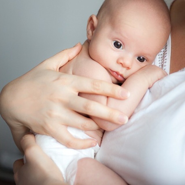 A mother holds her baby close, a gentle moment of love and bonding. Ideal for family or childcare concepts.