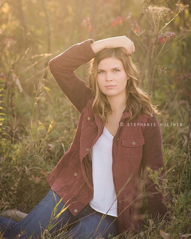 A woman poses in a field wearing a jacket. Ideal for lifestyle and outdoor campaigns.