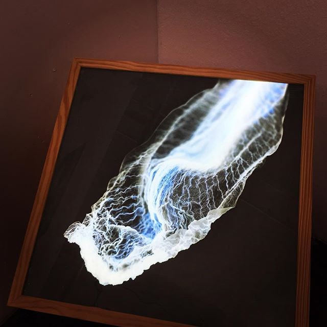 Abstract artwork in a wooden frame with blue and white colors displayed in a corner.