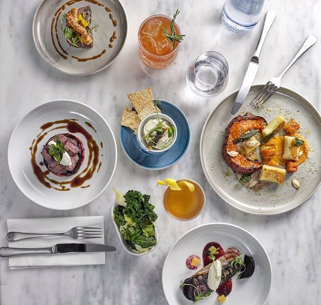 Overhead view of assorted dishes and drinks on a marble table, perfect for culinary and restaurant content.