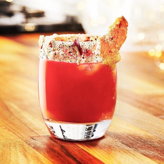 A vibrant, garnished cocktail in a glass, perfect for a celebratory toast or social media post.