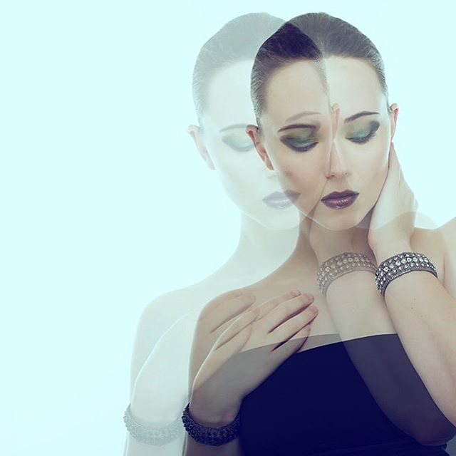 Elegant portrait of a woman with makeup, soft lighting and a cool toned background.