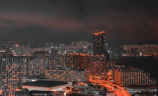 A nighttime cityscape showcases Hong Kong's stunning skyline with glowing buildings and lights.