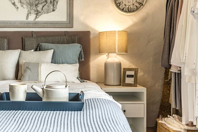 A cozy bedroom scene featuring a tea set on the bed, creating a relaxing and inviting atmosphere.