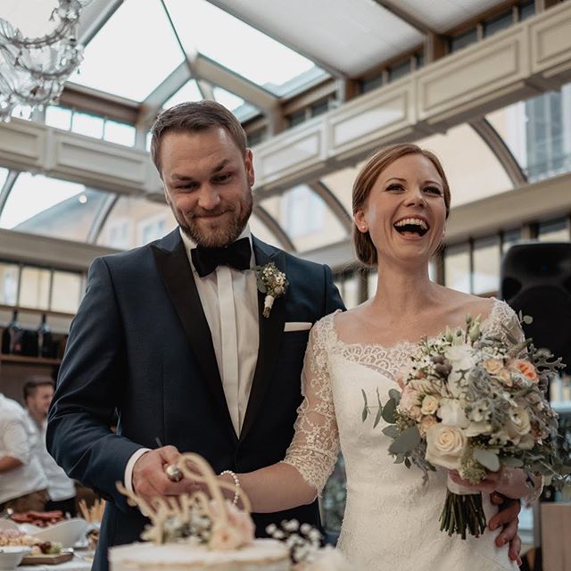 A happy bride and groom cutting their wedding cake together at their wedding reception.