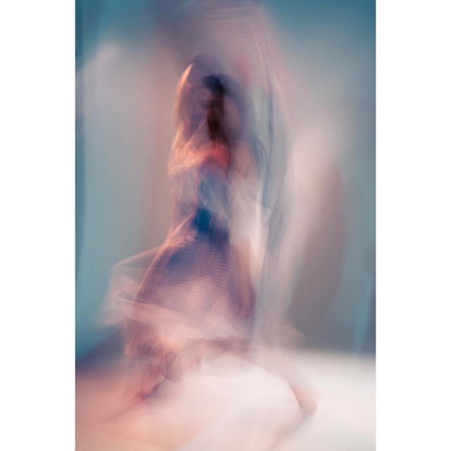 A blurred, artistic image of a woman in a dress for editorial or advertising use.