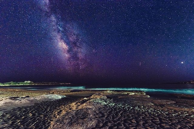 A scenic view of the Milky Way over a tranquil beach at night, perfect for travel and astronomy enthusiasts.