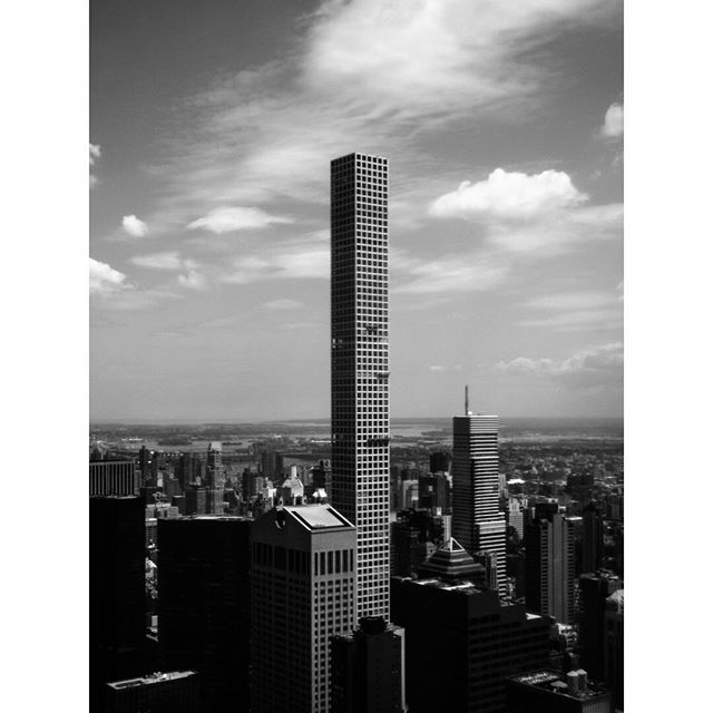 A black and white cityscape featuring modern skyscrapers against a cloudy sky in New York City, capturing urban architecture.
