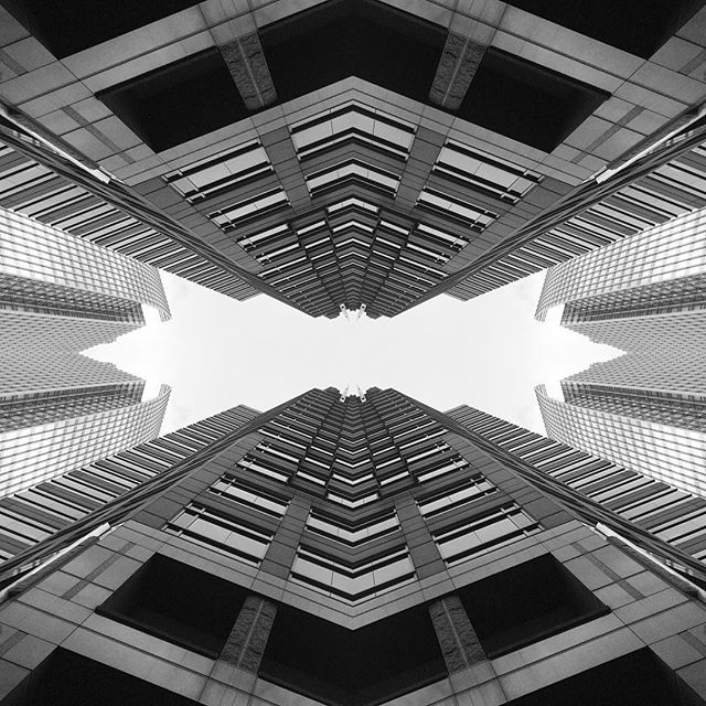Abstract low-angle view of modern skyscrapers in black and white, creating a powerful urban cityscape.