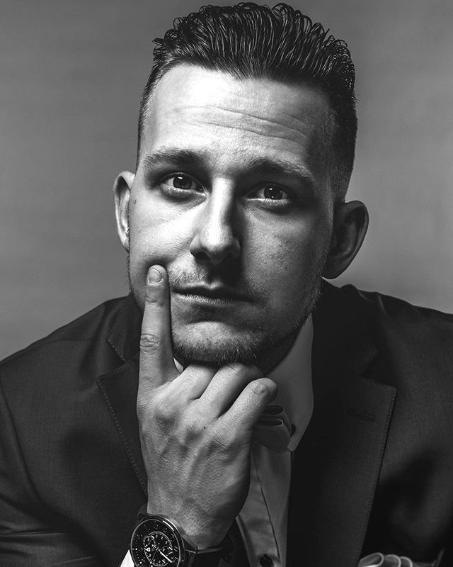 A monochrome portrait of a man in a suit looking serious and thoughtful.