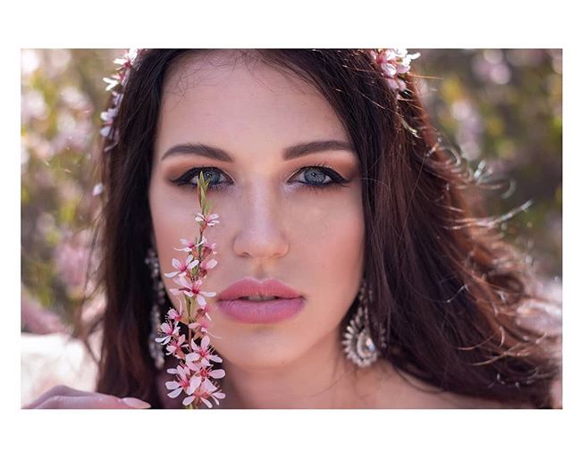 Close-up portrait of a brunette woman with flowers, ideal for beauty and spring fashion campaigns.