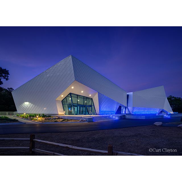 Modern building with geometric design illuminated at night. A striking architectural statement.