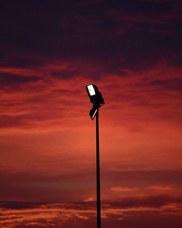 A single light illuminates the sky at sunset.