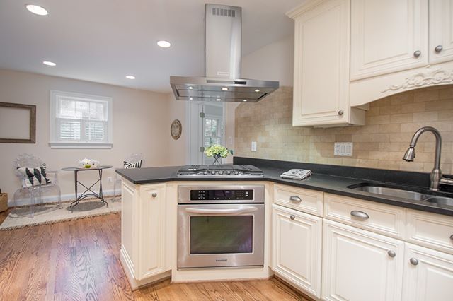 A modern kitchen features stainless steel appliances, white cabinetry, and dark countertops.