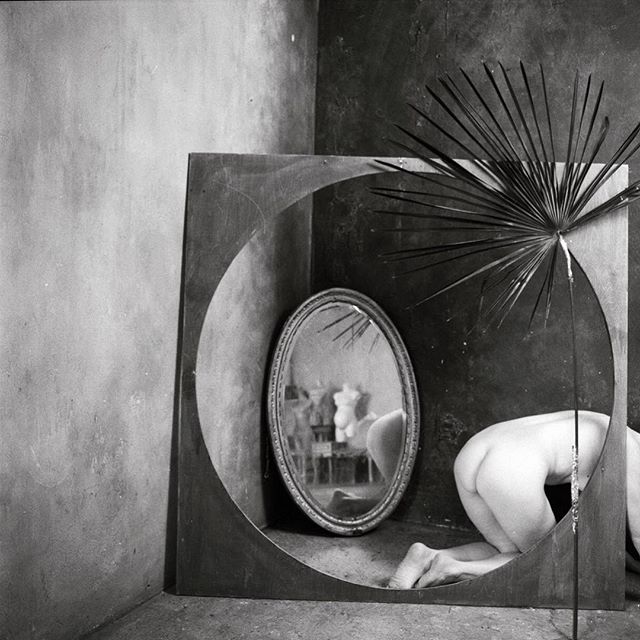 Artistic nude study featuring a woman reflected in a mirror, creating a captivating visual narrative.