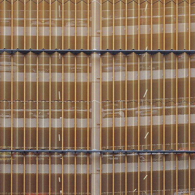 Detailed shot of a modern building facade featuring an intricate metal screen design for architectural use.