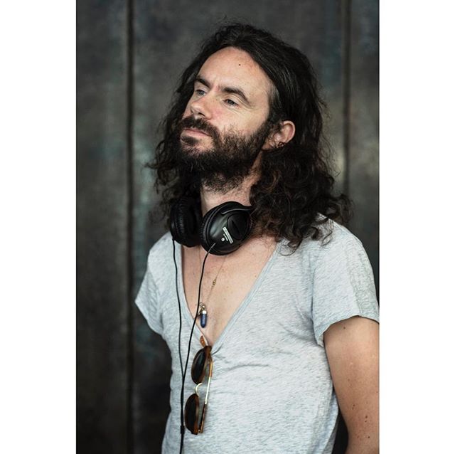 A man with a beard and headphones poses in a medium shot, ideal for lifestyle and music-related content.