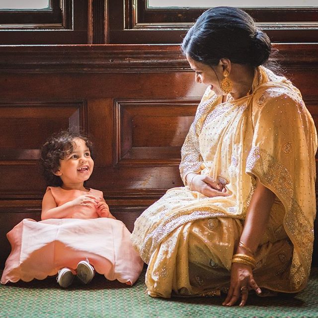 A grandmother and granddaughter share a loving moment sitting together and smiling at each other.