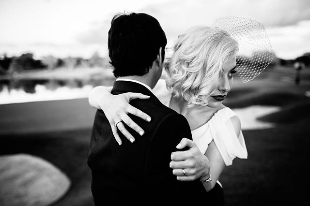 A bride and groom embrace in a black and white image, showcasing their wedding rings and the start of their new life together.