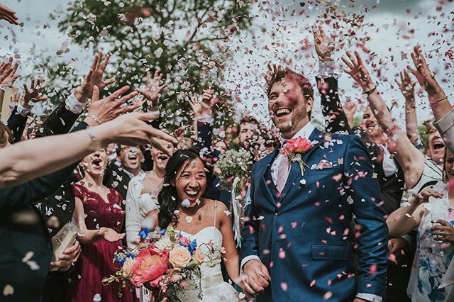 A happy bride and groom are showered with confetti during their wedding celebration with family and friends.